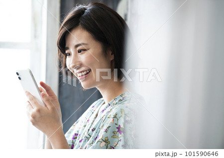 スマホを操作する若い女性 笑顔 スマホを操作する若い女性 笑顔 101590646
