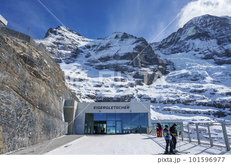 Eigergletscher text on exterior of modern building with beautiful majestic snow covered mountains under sky during sunny day at Jungfrau, Switzerland, winter holiday and nature concept 101596977