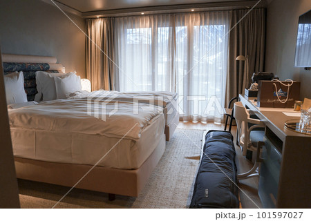 Pillows and duvets arranged on cozy comfortable twin beds in elegant bedroom at luxurious hotel, alpine hotel interior design concept Pillows and duvets arranged on cozy comfortable twin beds in elegant bedroom at luxurious hotel, alpine hotel interior design concept 101597027