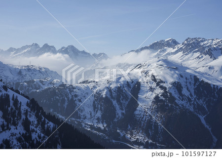 Scenic view of snow covered mountains with ski resort in front of sky on sunny day, winter holiday travel concept Scenic view of snow covered mountains with ski resort in front of sky on sunny day, winter holiday travel concept 101597127