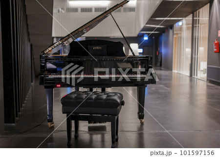 Piano with black stool displayed as decoration in fancy luxurious tourist resort, luxury travel concept Piano with black stool displayed as decoration in fancy luxurious tourist resort, luxury travel concept 101597156