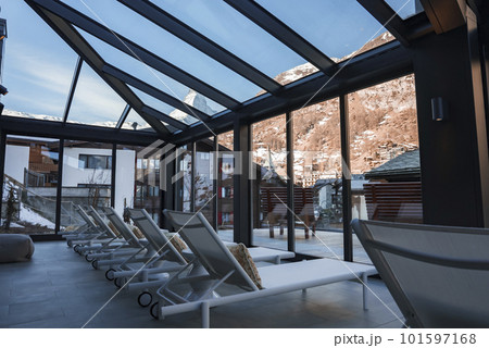 Empty white deck chairs arranged in a row under skylight in front of windows in luxurious room at modern hotel, luxury vacation and holiday concept for tourists 101597168