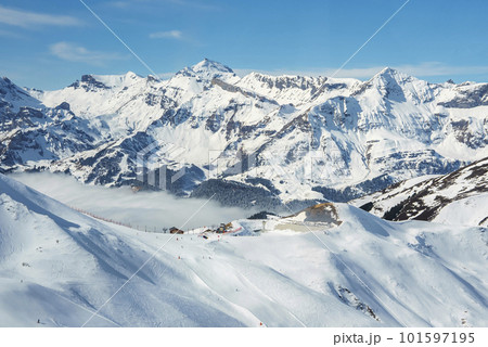 Scenic and beautiful view of majestic snowcapped mountain ranges with blue sky in background during sunny day at Jungfrau, Switzerland, winter holiday and nature concept 101597195