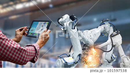 Industrial robot operator in factory holding tablet Industrial robot operator in factory holding tablet 101597538