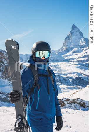 Young skier enjoying Zermatt ski resort. Beautiful sunny day with a skier up in the mountains. Sports model. Young skier enjoying Zermatt ski resort. Beautiful sunny day with a skier up in the mountains. Sports model. 101597995