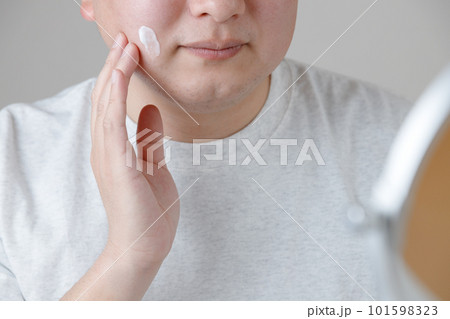 髭剃りや洗顔の後のスキンケアとアジア人男性。乳液やクリームを顔に塗っている。 髭剃りや洗顔の後のスキンケアとアジア人男性。乳液やクリームを顔に塗っている。 101598323