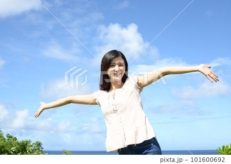 青空を背に手をひろげる女性 青空を背に手をひろげる女性 101600692