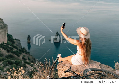 Selfie woman in cap and tank top making selfie shot mobile phone post photo social network outdoors on sea background beach people vacation lifestyle travel concept. Selfie woman in cap and tank top making selfie shot mobile phone post photo social network outdoors on sea background beach people vacation lifestyle travel concept. 101600787