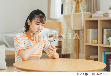 リビングでスマホを使う若い女性 101604838