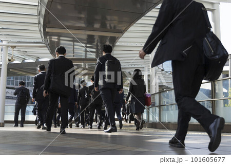 朝の通勤をするビジネスマンたちの後ろ姿 朝の通勤をするビジネスマンたちの後ろ姿 101605677