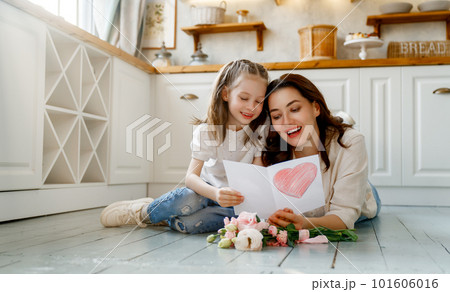 Daughter giving mother bouquet of flowers. 101606016