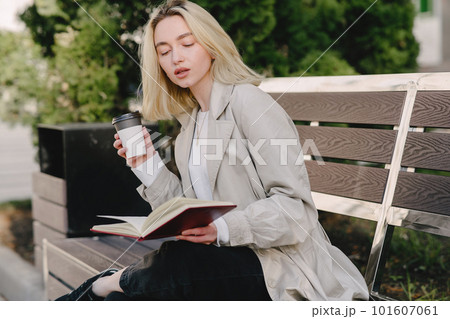 Portrait of beautiful blond. Model in summer city. Girl sitting on a bench. Portrait of beautiful blond. Model in summer city. Girl sitting on a bench. 101607061