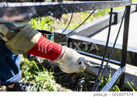 hand in glove paints fence of grave in cemetery 101607574