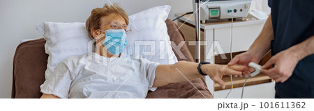 Nurse checking with fingertip pulse oximeter oxygen saturation of patient blood in hospital 101611362