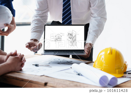 Architect and Engineer working with blueprints for architectural plan, engineer sketching a construction project, green energy concept 101611428
