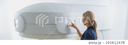 Radiologist controls MRI or CT or PET Scan with female patient undergoing procedure 101611476
