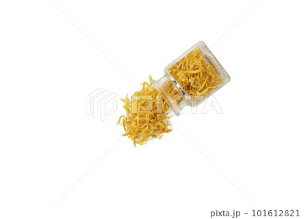 Dried Calendula or Marigold petals falling from glass jar isolated on white background. 101612821