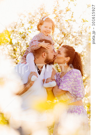 in the sun's rays. happy family in a blooming spring garden. in the sun's rays. happy family in a blooming spring garden. 101615927