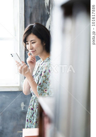 スマホを操作する若い女性 微笑み スマホを操作する若い女性 微笑み 101617886