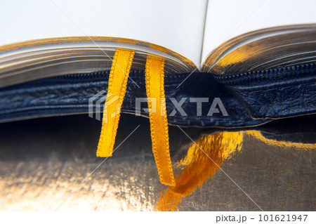 Yellow ribbon bookmark for a book. Open bible. The study of literature. 101621947
