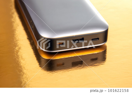 Powerbank portable on a golden background. Electronic devices for charging gadgets and smartphones Powerbank portable on a golden background. Electronic devices for charging gadgets and smartphones 101622158