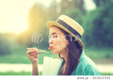 young caucasian woman eating thai food at sunset 101622350