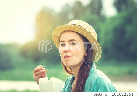 young caucasian woman eating thai food at sunset 101622351