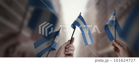 A group of people holding small flags of the Nicaragua in their hands A group of people holding small flags of the Nicaragua in their hands 101624727