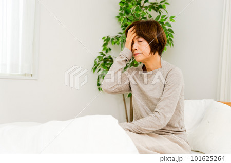 寝起きで頭を抱える50代から60代の女性 寝起きで頭を抱える50代から60代の女性 101625264