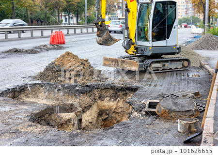 Repair of a sewer collector in the middle of the carriageway of a city street with the help of small road equipment. Repair of a sewer collector in the middle of the carriageway of a city street with the help of small road equipment. 101626655