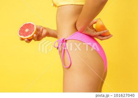 Woman in swimsuit with healthful fresh orange in hand Woman in swimsuit with healthful fresh orange in hand 101627040