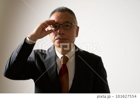 真剣な表情で視線を向けるスーツ姿のシニア男性 101627554