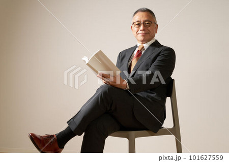 本を持って椅子に座るシニア男性 101627559