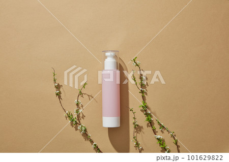 Top view of a pink bottle with empty label decorated on minimalist brown background. Blank space for adding text 101629822