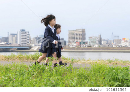 春の河川敷を走る幼稚園の制服を着た姉妹 春の河川敷を走る幼稚園の制服を着た姉妹 101631565