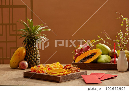 Tet trays is traditional on new year celebration. Jam, five - fruit tray and red envelope on wooden table. This occasion is the biggest festival for Vietnamese people. Tet trays is traditional on new year celebration. Jam, five - fruit tray and red envelope on wooden table. This occasion is the biggest festival for Vietnamese people. 101631993