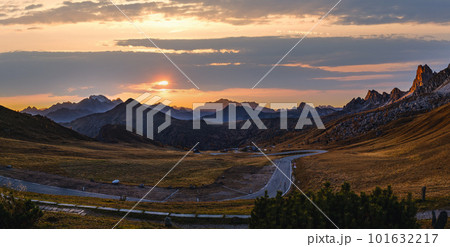 Sun glow in evening hazy sky. Mountain panoramic peaceful view from Giau Pass. 101632217
