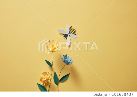 Flowers with many colors and a paper bee on light yellow background. Empty area for product or text. Graphic design for spring Flowers with many colors and a paper bee on light yellow background. Empty area for product or text. Graphic design for spring 101638437