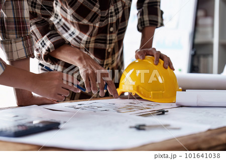 Architect and Engineer working with blueprints for architectural plan, engineer sketching a construction project, green energy concept Architect and Engineer working with blueprints for architectural plan, engineer sketching a construction project, green energy concept 101641038