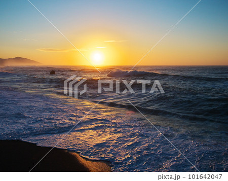 伊良湖岬堀切町海岸　荒波と日の出の朝焼けに染まる海 101642047