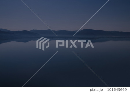 Silhouette of mountains near lake at the early morning with clear sky Silhouette of mountains near lake at the early morning with clear sky 101643669