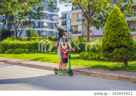 The father riding the electric scooter with his son in the city The father riding the electric scooter with his son in the city 101647021