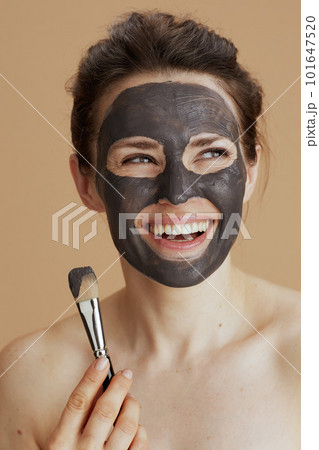 smiling woman with brush and facial mask 101647520