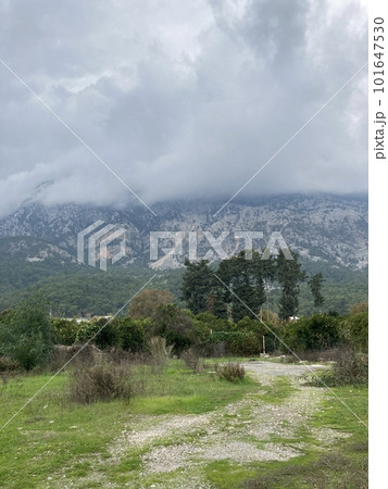 Low fluffy clouds hang over the high mountains, cover their peaks Low fluffy clouds hang over the high mountains, cover their peaks 101647530