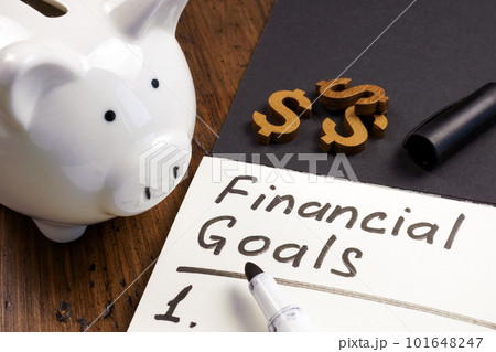 Piggy bank and open notepad with inscription financial goals and list. 101648247