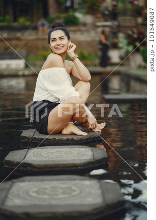 girl exploring a beautiful park in Bali. Brunette girl dressed in stylish clothing posing in a beautiful location girl exploring a beautiful park in Bali. Brunette girl dressed in stylish clothing posing in a beautiful location 101649087