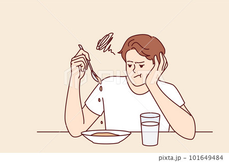 Man suffers from lack of appetite sitting at table in kitchen and does not want to eat breakfast Man suffers from lack of appetite sitting at table in kitchen and does not want to eat breakfast 101649484