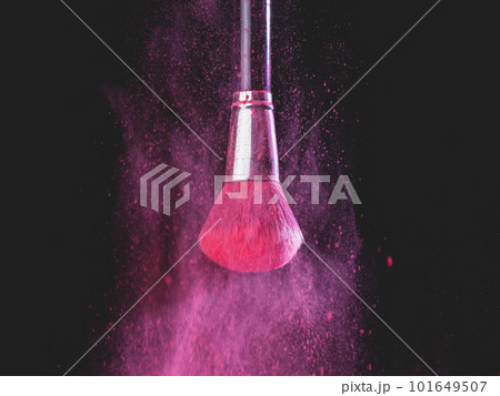 Make-up brush with pink powder splashes explosion on black background. Beauty concept 101649507