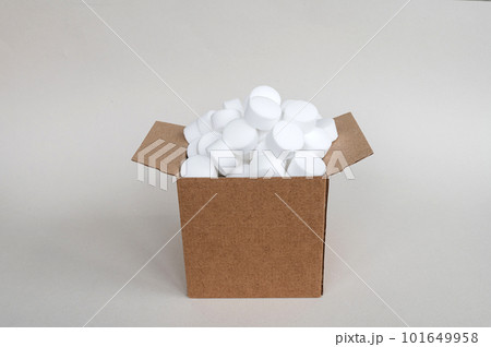 White round dishwasher salt tablets in a box. A set of white capsules in an open box White round dishwasher salt tablets in a box. A set of white capsules in an open box 101649958