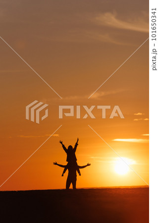 silhouettes of couple at sunset against bright sun and sky. man and woman have fun in nature silhouettes of couple at sunset against bright sun and sky. man and woman have fun in nature 101650341